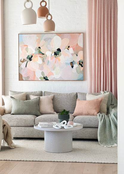 Modern living room with a gray sofa, abstract painting, and pink curtains.