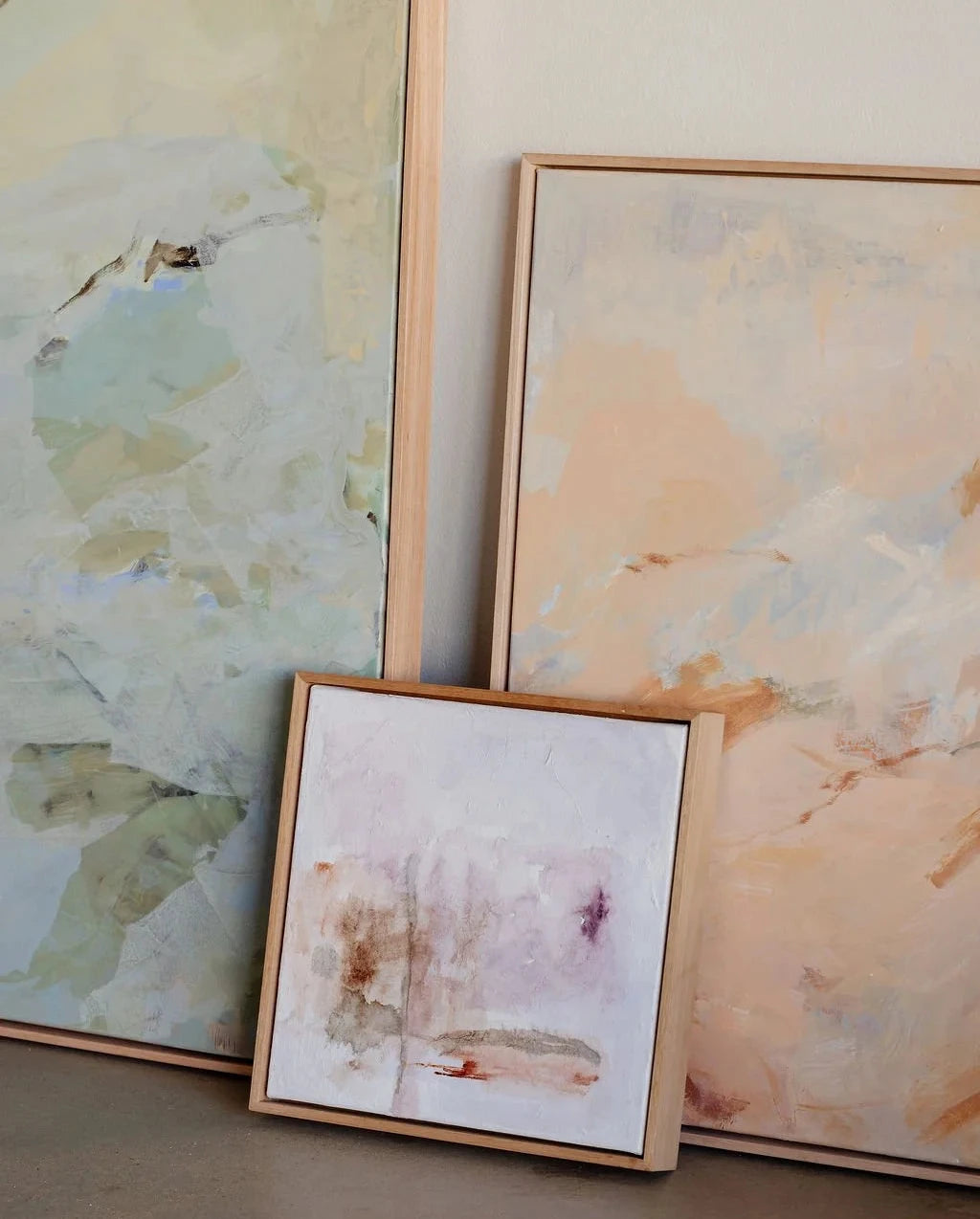 Three framed abstract artworks on a neutral wall.