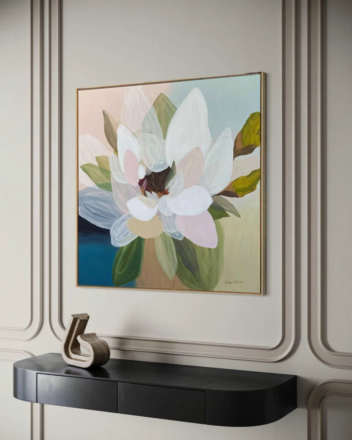 Framed floral artwork on a wall above a black console table.