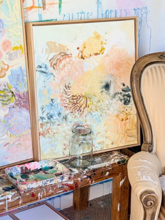 Golden Hour original painting in an oak frame on a paint-covered table in Prudence De Marchi's studio.