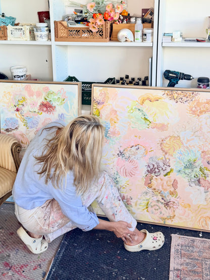 Prudence De Marchi crouching beside Under the Waves while arranging FLOAT paintings in her studio.