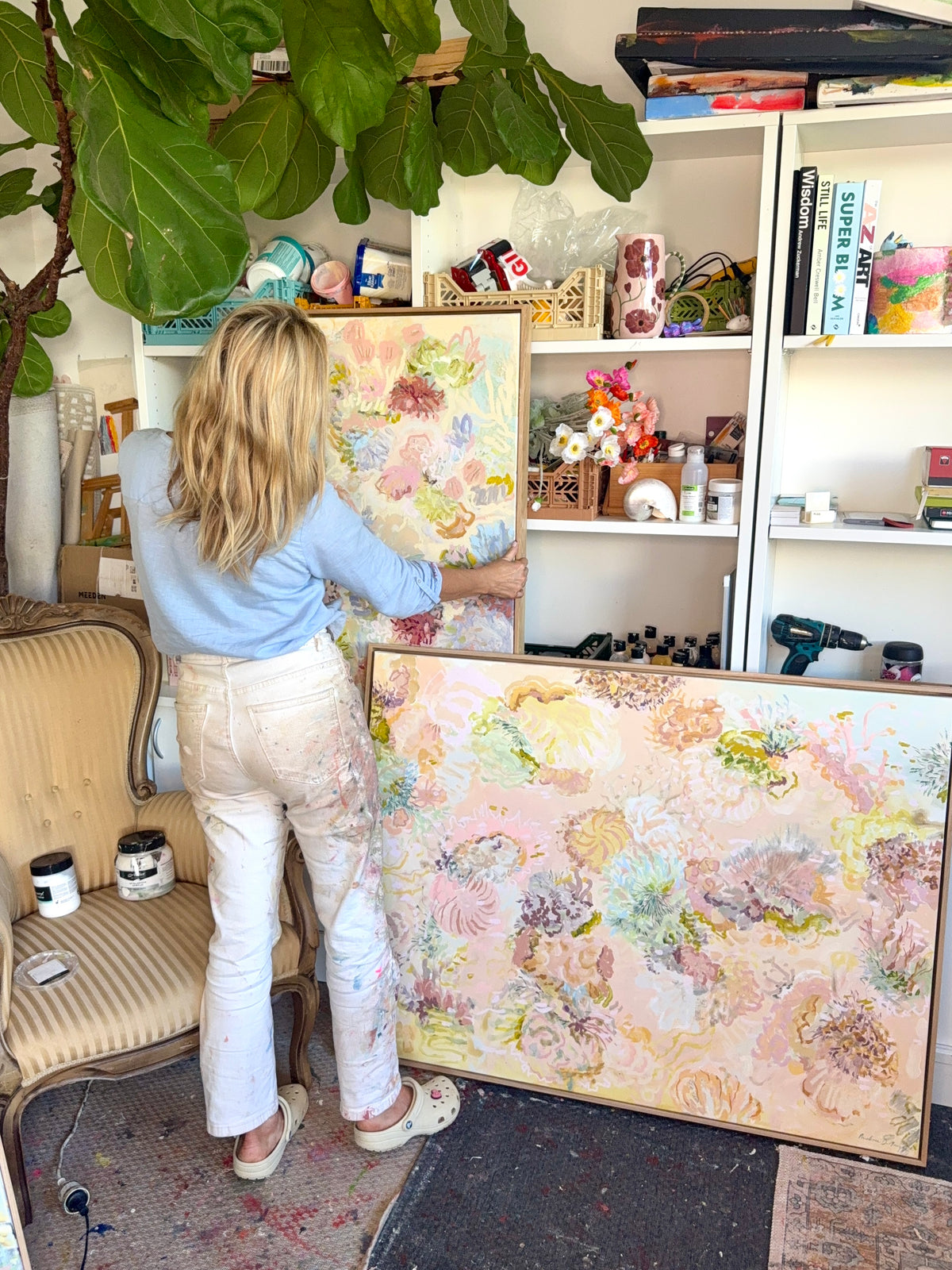Prudence De Marchi standing beside Under the Waves and other FLOAT paintings in her daylight studio.